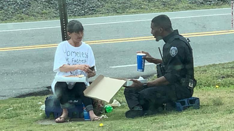 A police officer spent his lunch break sharing pizza with a homeless woman and it was captured in a heartwarming photo